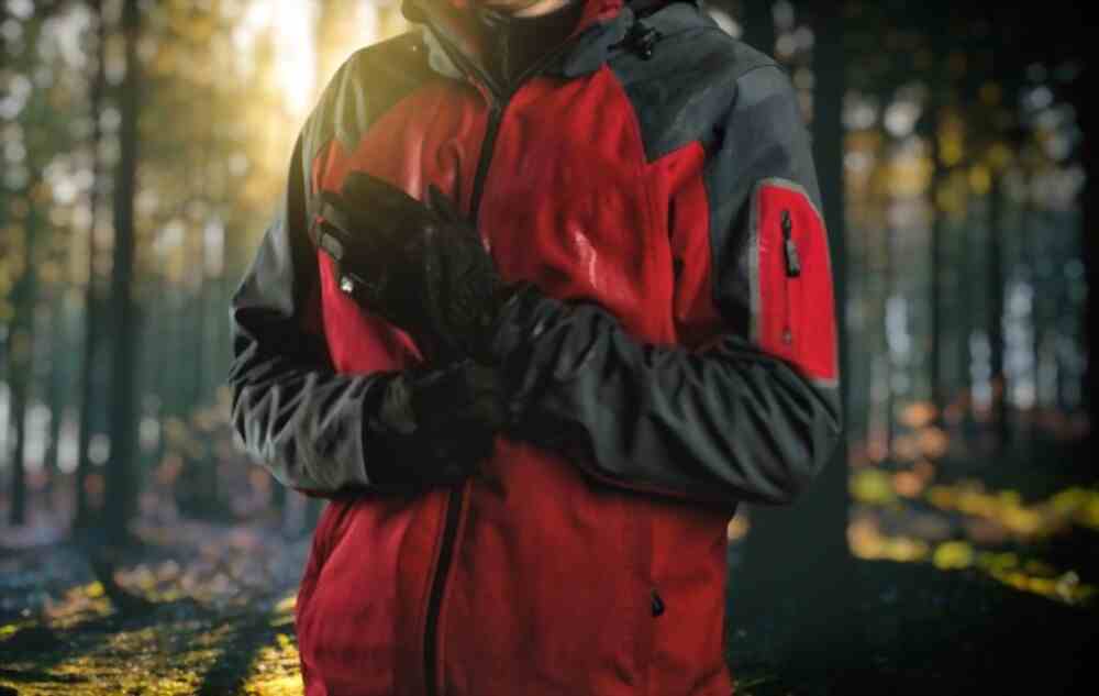 A man wearing red and black insulation clothing in a jungle